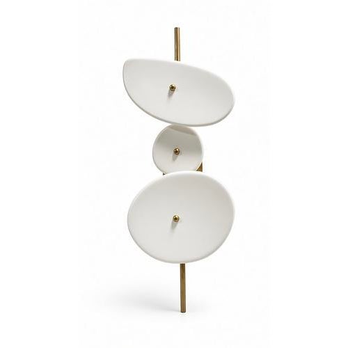 A pair of Elsa Foulon Achille wall sconces. Each has three ceramic discs on a hammered brass structure. Two light sources...