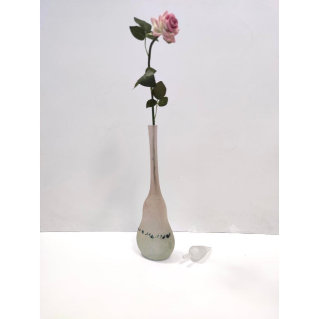 Italy, 1970s. This bottle / vase is made in hand-blown polychrome scavo glass, with a etched and blown clear glass cap. It...