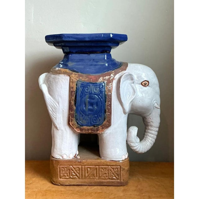 This vintage ceramic stool is sculpted in the charming form of a standing elephant, its gently curved trunk, expressive...