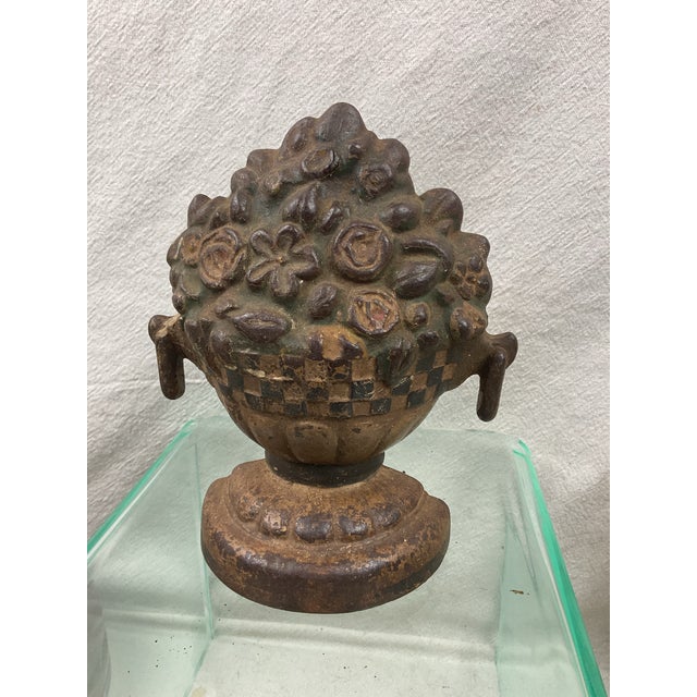 Antique iron doorstop with worn painted finish-flowers in basket on pedestal base. 8” tall 5” wide 2 1/4” deep