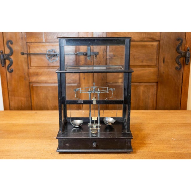 This 20th-century French scale encased in glass is a functional and decorative piece that reflects a blend of...