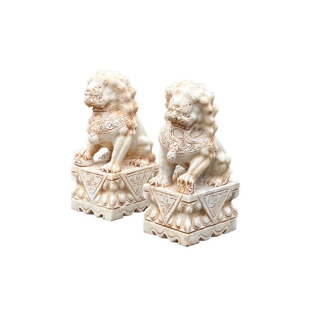 This is a pair of handcrafted distressed marks tan cream white marble stone Foo Dogs with traditional Chinese details....