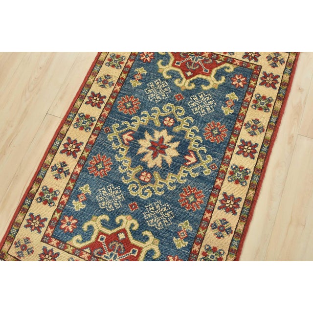 A traditional tribal Caucasian Kazak rug hand-knotted with an all-wool pile on a cotton foundation. This oriental rug...