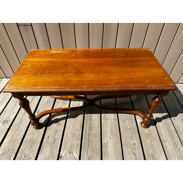 An elegant solid walnut coffee table bearing the famous salamander mark of André Mailfert, a renowned French cabinetmaker...