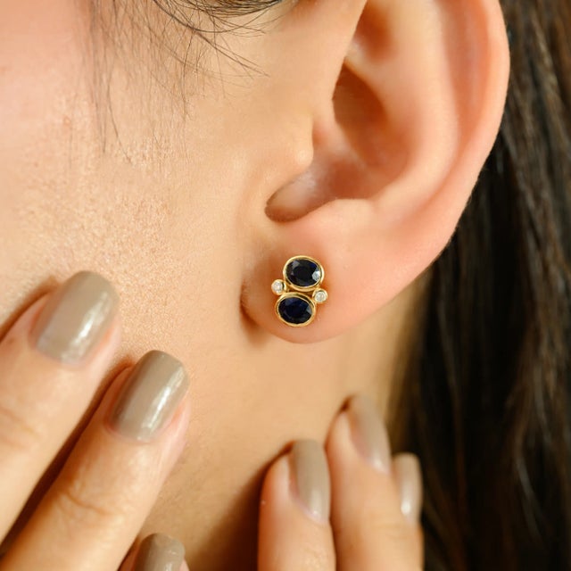 These exquisite stud earrings meticulously crafted in 14kt yellow gold. Each earring showcases two richly hued oval-cut...