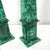 A striking pair of monumental obelisks crafted from richly figured natural malachite, showcasing the gemstone's...