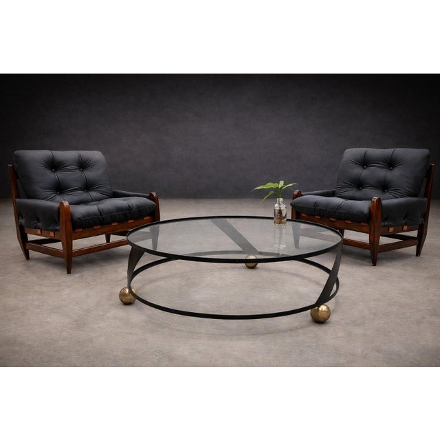A refined circular coffee table from 1960s Brazil, executed in plated and painted metal with a new glass top. The two-tier...