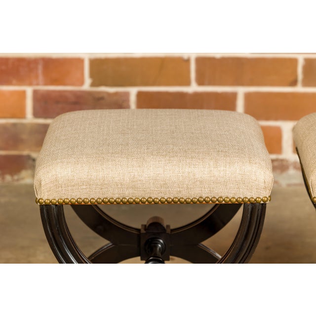 A pair of Austrian 1900s black stools from Vienna with X-Form bases, turned stretchers and new custom linen upholstery....