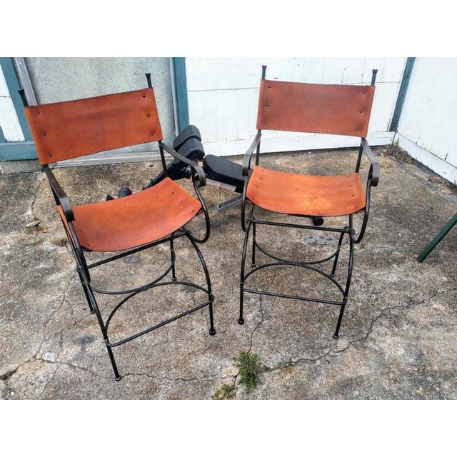 Pair of Legacy Counterstools by Charleston Forge A pair of Charleston Forge wrought iron and leather barstools. Forged...