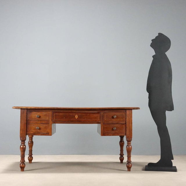 Open walnut desk with alternating ebony, maple, and walnut trim. Designed for a double workstation, it features a central...