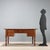 Open walnut desk with alternating ebony, maple, and walnut trim. Designed for a double workstation, it features a central...