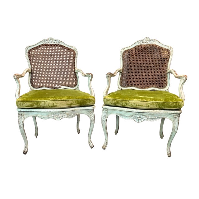 A fine pair of eighteenth century French Louis XV fauteuils, circa 1750. The chairs are painted white and have caned seats...
