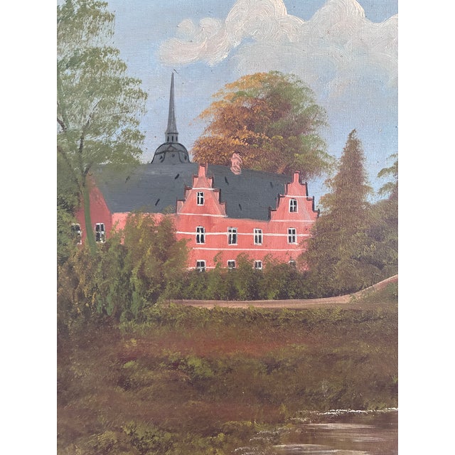 This original vintage oil painting, created around 1930, shows a large manor house beside a lake, surrounded by trees and...