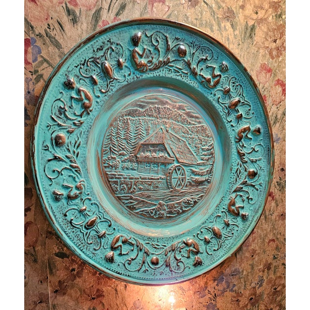 Hand hammered copper decoration charger, farm landscape in center, surrounded by motif of a little boy playing music...
