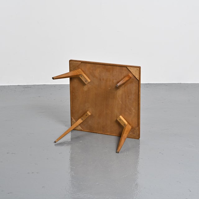 Coffee table made in France in the 1950s. The rectangular, rimmed top is veneered in ash and rests on four slightly...