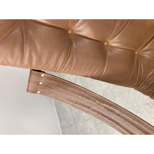 Attractive mid century leather armchair with tufted leather cushions and sling leather armrests. Designe dby Geoffrey...