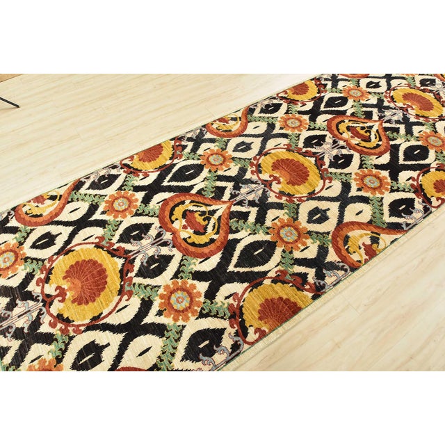 This modern traditional Suzani runner is hand-knotted with an all-wool pile on a cotton foundation. This rug is new and in...