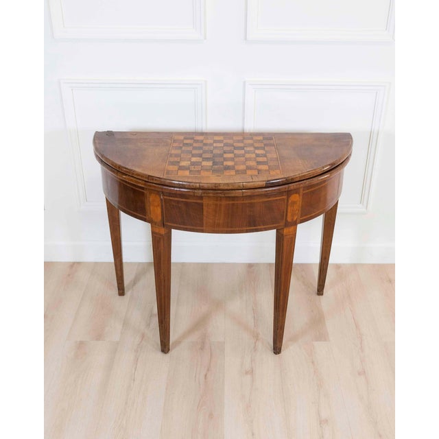 A refined early 19th century walnut half-moon game table, this elegant piece combines sophisticated design with...