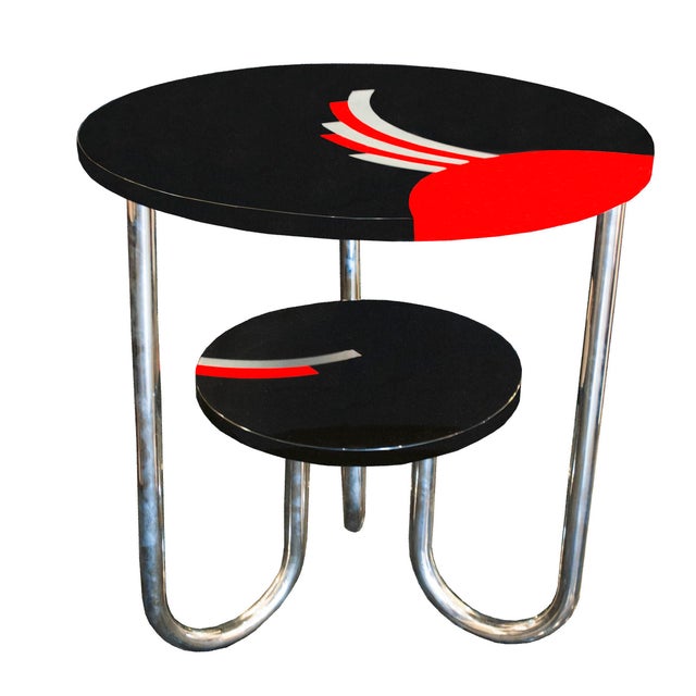 Bauhaus-Deco round two-tiered side table in black lacquer with red lacquer and silver leaf details on both tops. Curved...