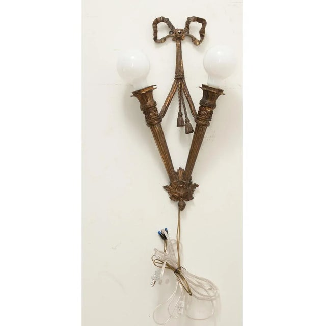 Dimensions: 21 ½” H x 10 ½” W x 4 ¼” D A French Louis XVI style two-bulb single sconce. This Neoclassical-inspired bronze...