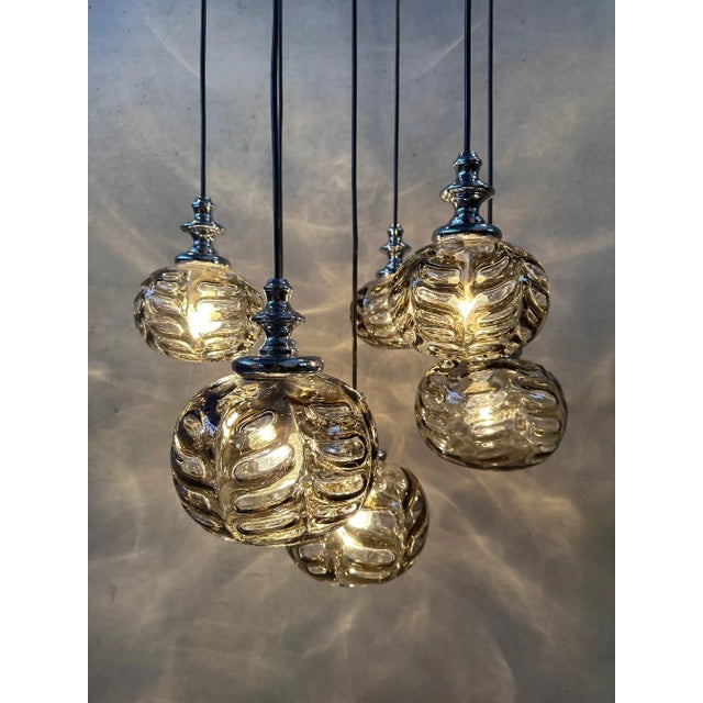 Large vintage cascade pendant lamp with 7 lights. Mouth-blown smoked glass globes with leaf reliefs. Marked with the...