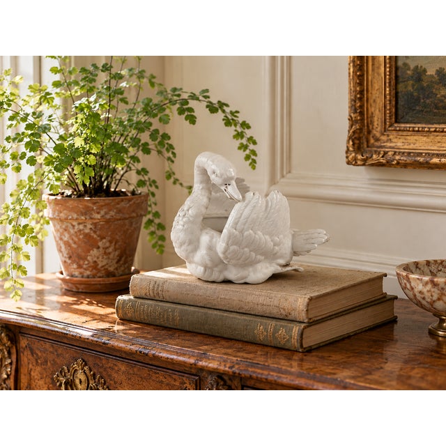 A charming antique white bisque porcelain swan planter, distinguished by its gracefully curved neck, beautifully modelled...