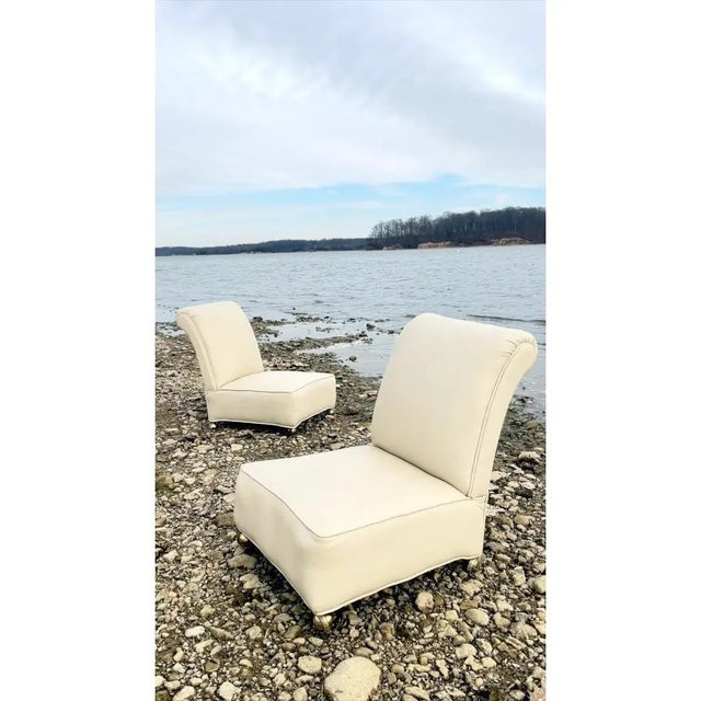 A pair of 1950s Italian Mid-Century Modern slipper chairs, reupholstered in white leather in the 1970s. These armless...