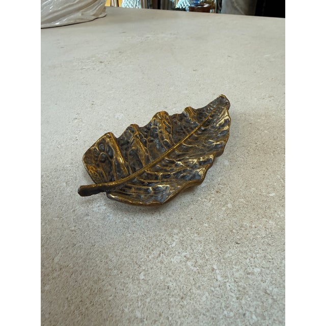 Beautiful vintage brass dish shaped like a natural leaf, featuring detailed veining and an organic, sculptural form. The...