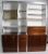 Stunning wall unit having rosewood cabinets with white Formica surfaces, brushed metal trim, and tinted glass shelves....