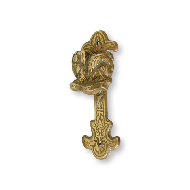 Welcome guests with the charming elegance of this antique Pekinese door knocker. Crafted from durable brass, it features a...