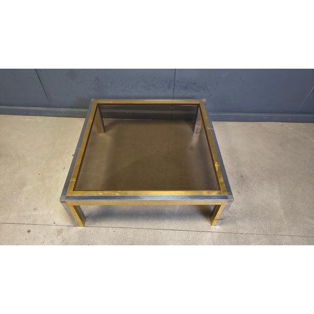 Chrome and brass coffee table with a smoked glass top Hollywood regency style. Condition: Patina on the brass/chrome,...
