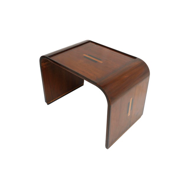 A Mid-Century Modern set of three teak nesting tables with rosewood inlay along the tops and on the two sides. The larger...