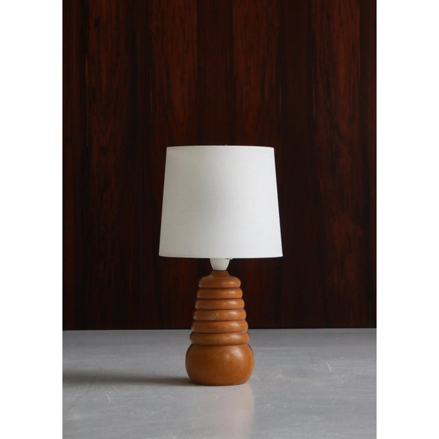 Charming unique table lamp in turned beechwood by a Danish cabinetmaker. Made in the 1950s Denmark. The lamp is equipped...