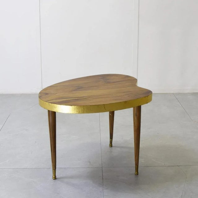 The tabletop has a sinuous, irregular shape reminiscent of a bean. This type of design was very popular in Midcentury...