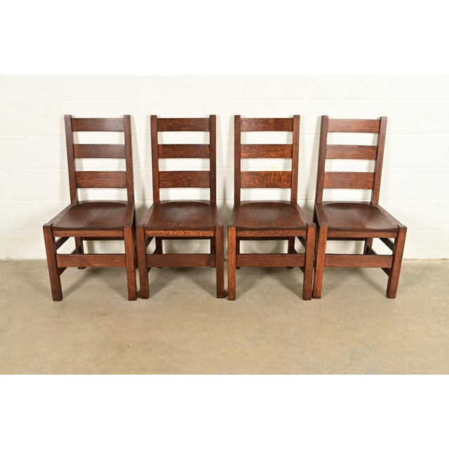 An exceptional set of four antique Mission or Arts & Crafts period solid quarter sawn oak ladder back dining chairs By...