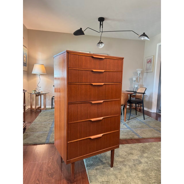 A mid century modern tallboy in teak by Austinsuite, circa 1960s. It features six drawers with contoured handles and...