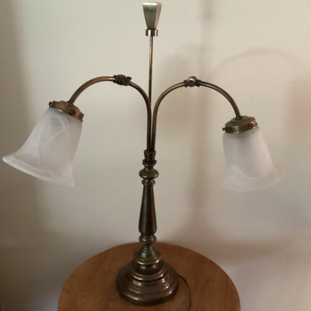 The Vintage Double Arm Brass Table Lamp with a fruited base and bell-shaped glass shades is a charming and unique lighting...