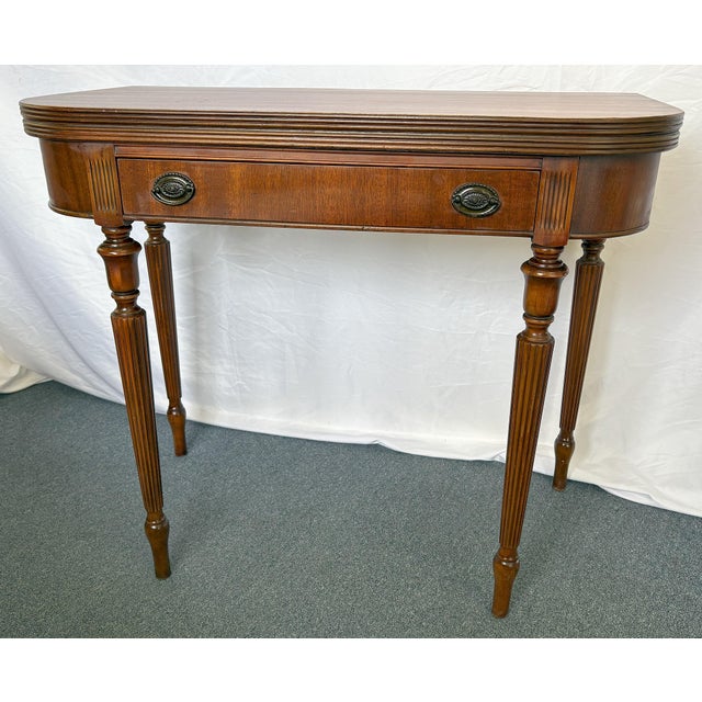 Wonderful vintage game table from the mid 20th century. This Federal style table is made of wood with a center drawer and...