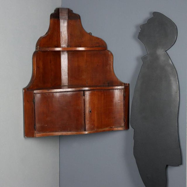 Walnut corner cabinet from the second half of the 19th century, designed to be hung. The structure features a curved front...