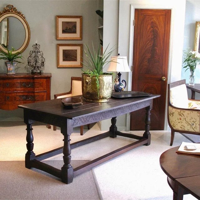 A late 17th century, ca. 1680-1700, English oak stretcher base table with a breadboard ended plank top. Baluster legs...