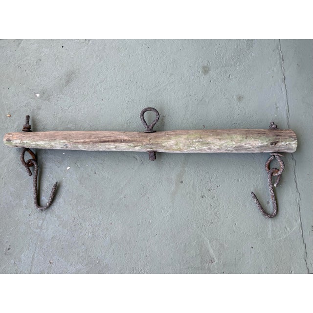 This authentic antique wall-mounted rack features a weathered solid wood beam fitted with original hand-forged iron...