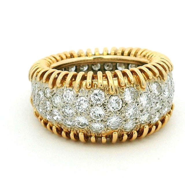 Striking vintage diamond band crafted in 18K yellow gold, featuring a wide ribbed design framing a central panel of pavé-...