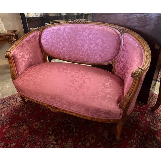 Turn of the century French walnut settee with new upholstery in a beautiful mauve rose color. 55" w x 38.5" h x 23"d