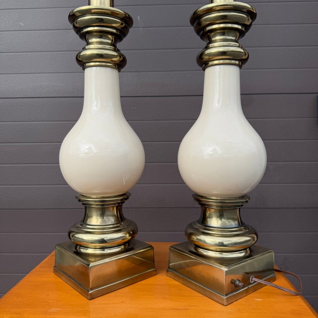 A pair of vintage beige porcelain Stiffel table lamps with square brass bases. American made. Circa late 20th century. Max...