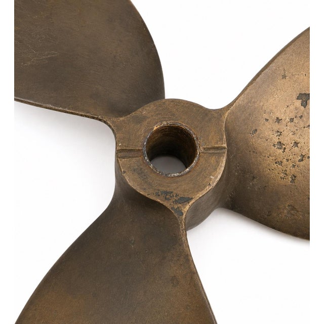 Vintage bronze three-blade marine propeller with original patina and authentic wear. A sculptural industrial maritime...