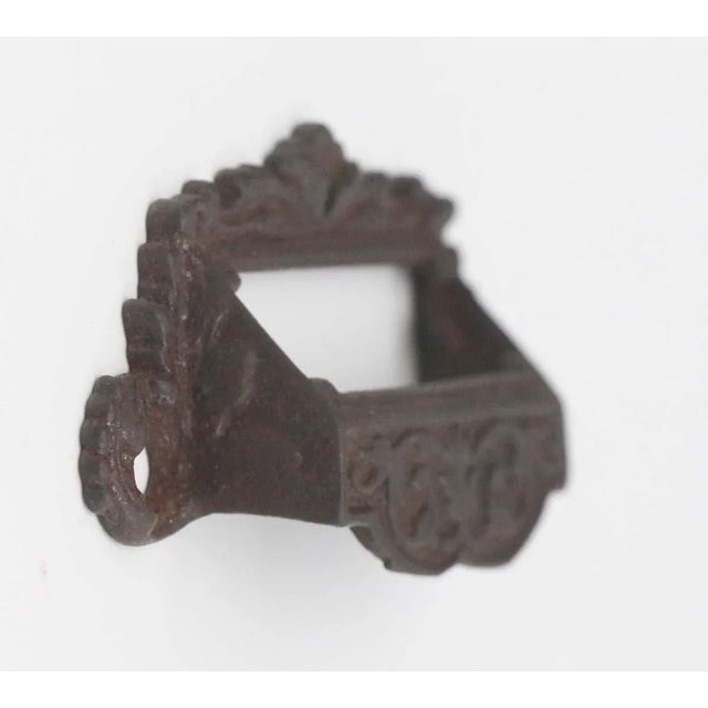 Antique cup or bin pull made of cast iron with Victorian details. There is a rectangular slot at the top for a label with...