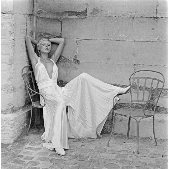 Grecian Fashion A model wearing a Grecian-style evening outfit with wide-legged trousers and a halterneck top in Paris,...