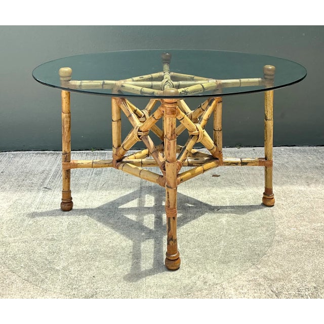 This vintage bamboo and glass dining table pairs the natural warmth of hand-worked bamboo with the clean transparency of...