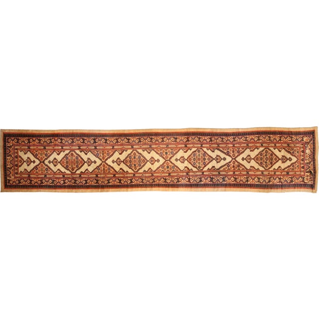 A highly decorative late 19th century Sarab runner carpet having a series of medallions overall on a beige field with...