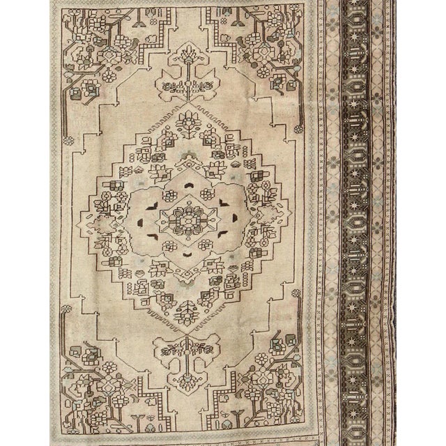 This striking vintage Turkish Oushak rug bears a neutral beige colored body that is highlighted by a dazzling design drawn...